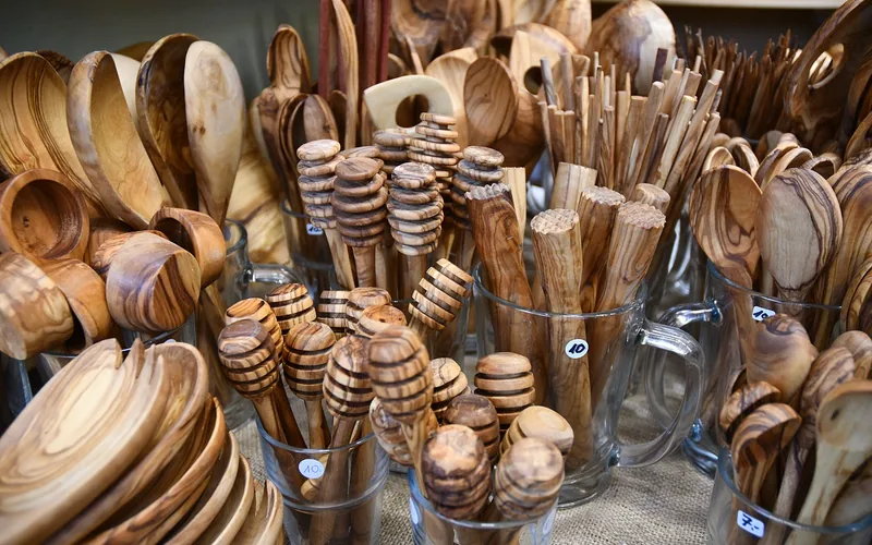 Craftsman carving a wooden spoon by hand in a woodworking workshop