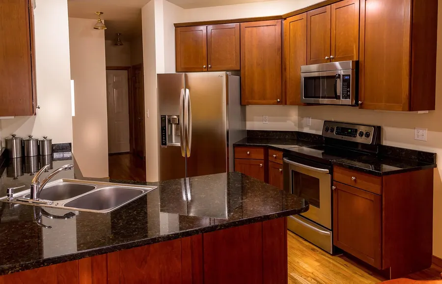 Kitchen with reddish-brown cherry wood cabinets and a granite countertop