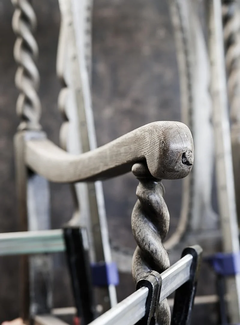 Wood clamps holding a board flat on a workshop bench while repairing warp