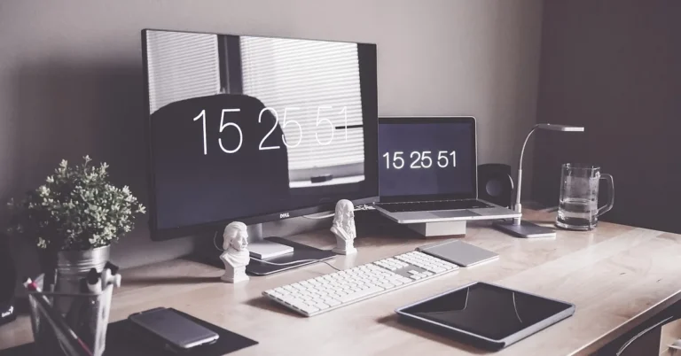 Organized home office desk with monitor raised on a wooden stand
