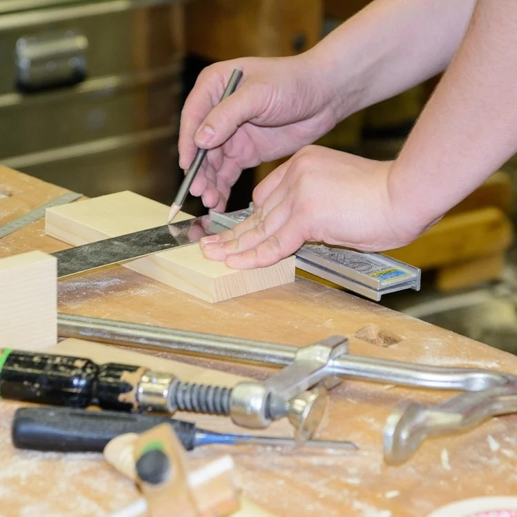 Marking and measuring a small wood block with a try square and pencil for a beginner project