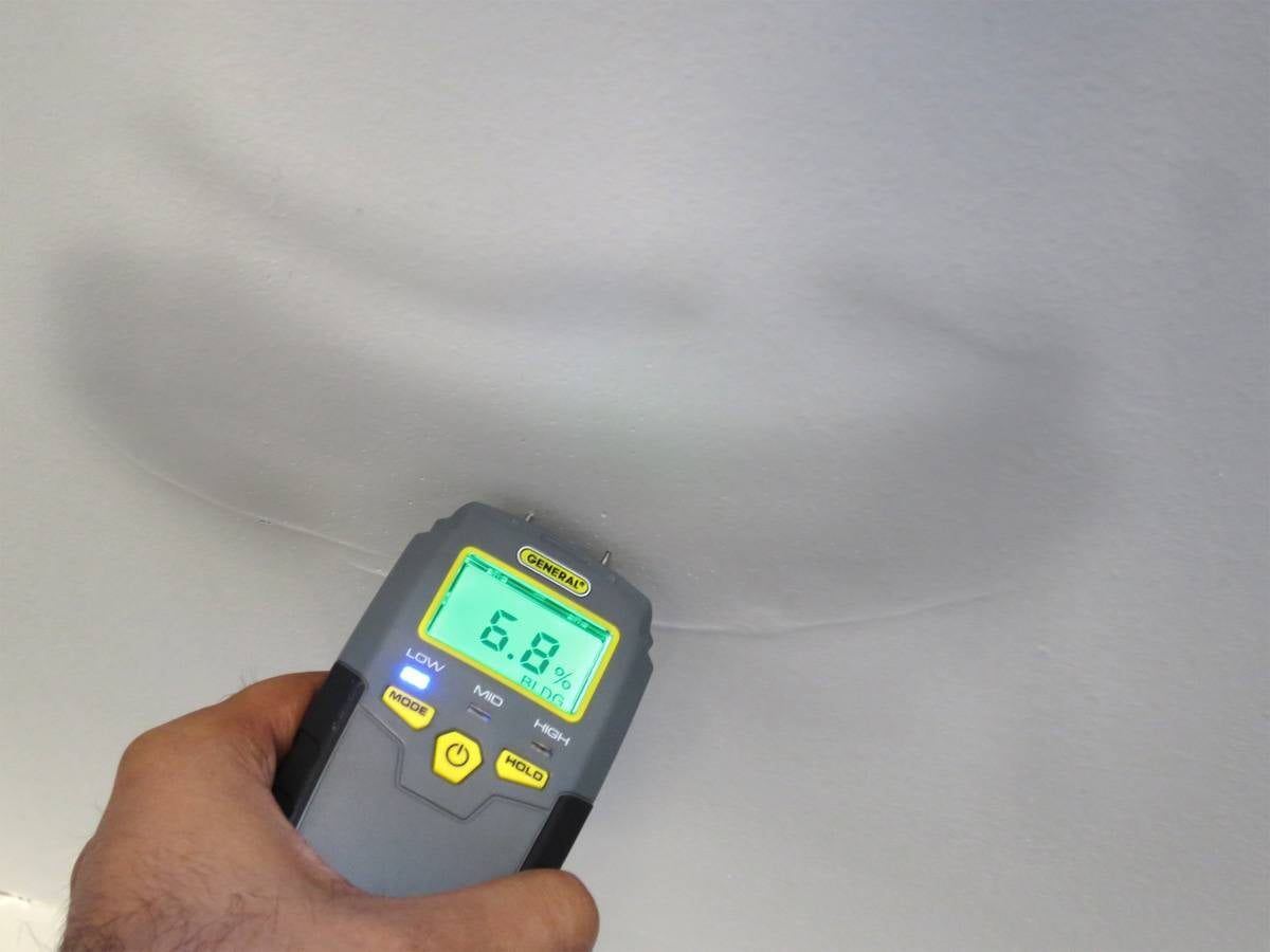 General Tools MMD4E digital pin-type moisture meter in use on a wall
