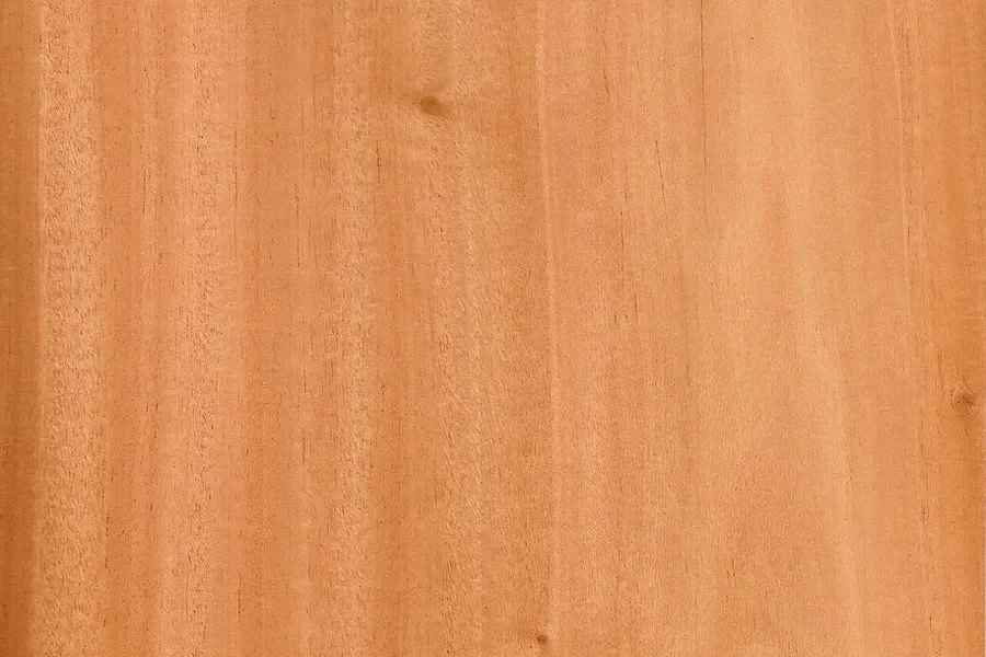 Close-up of a golden-brown mahogany-family wood surface with fine straight grain