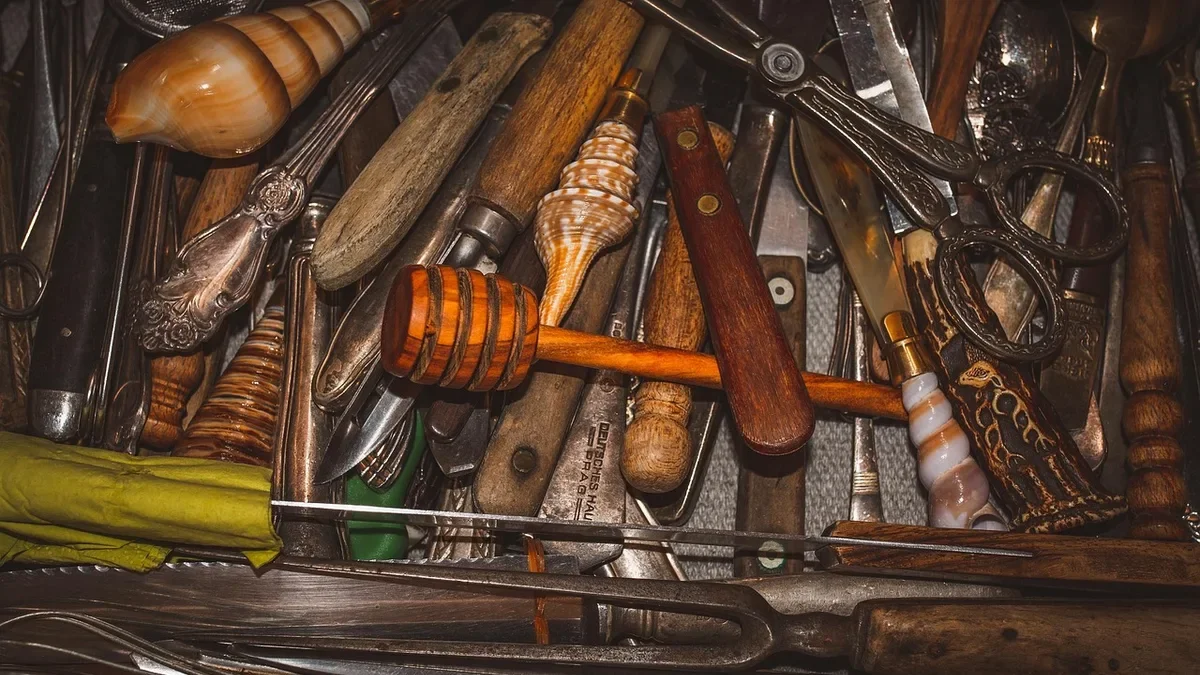 Cluttered kitchen utensil drawer full of mixed tools that needs wooden dividers