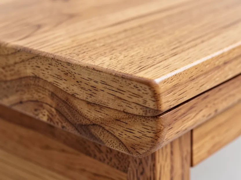 Close-up of finished maple wood furniture with natural finish showing grain detail