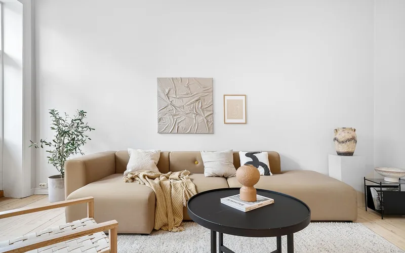Minimalist living room with a light wood floor and neutral upholstered sofa
