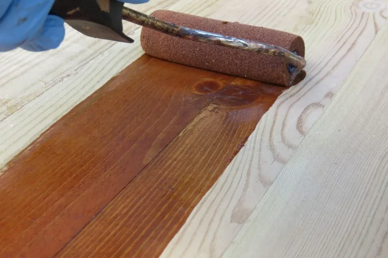 Hands stained with dark oil-based wood stain before cleaning