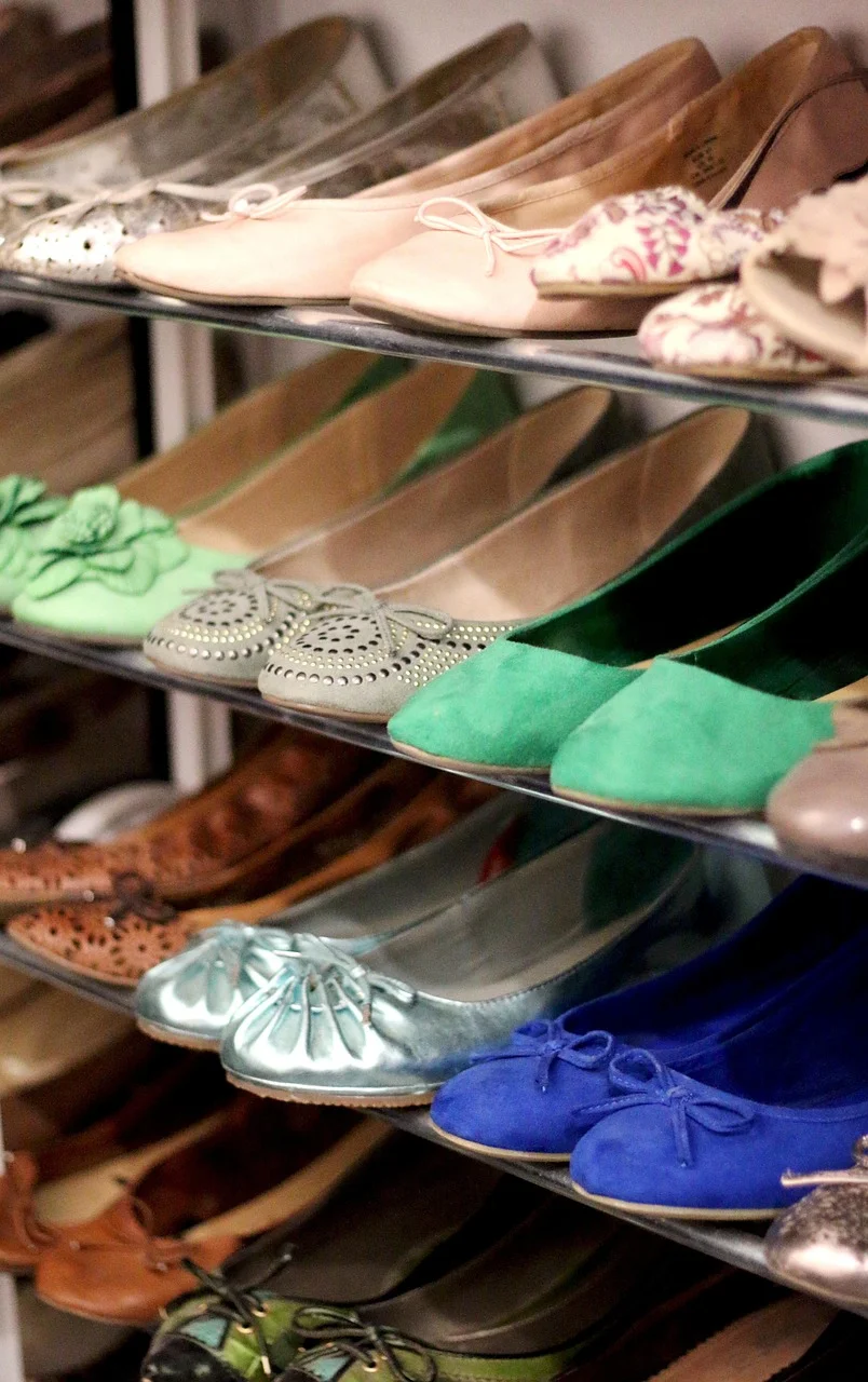 Neatly organized shoes on angled shelves in a home closet