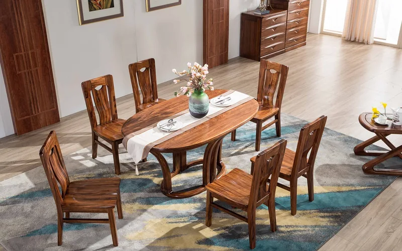 oval teak wood dining table with six matching wooden chairs set for a meal oval teak wood dining table with six matching wooden chairs set for a meal