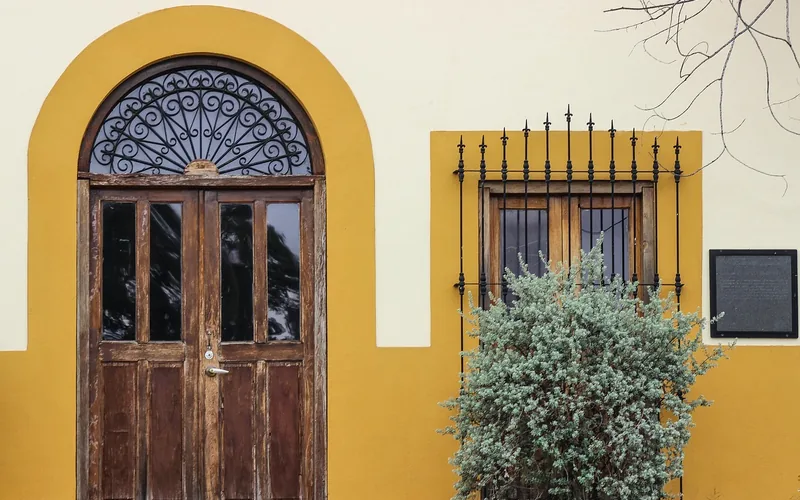 rustic antique wooden front door set into a house facade