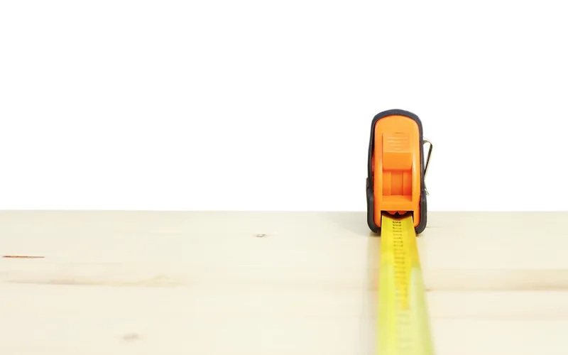 Tape measure laid along a pine board before cutting stool parts
