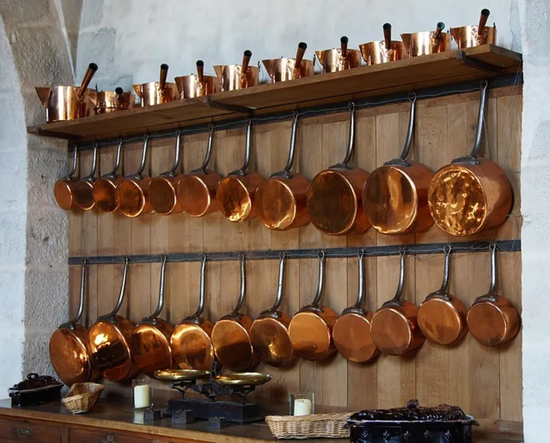 Open wood shelving in a kitchen holding cookware, an example of teak kitchen shelving