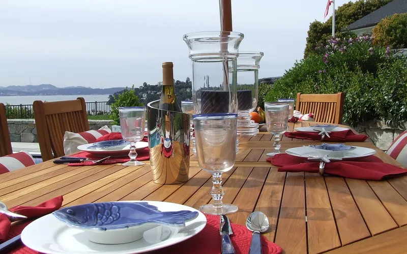Slatted teak outdoor dining table with a warm golden tone Slatted teak outdoor dining table with a warm golden tone