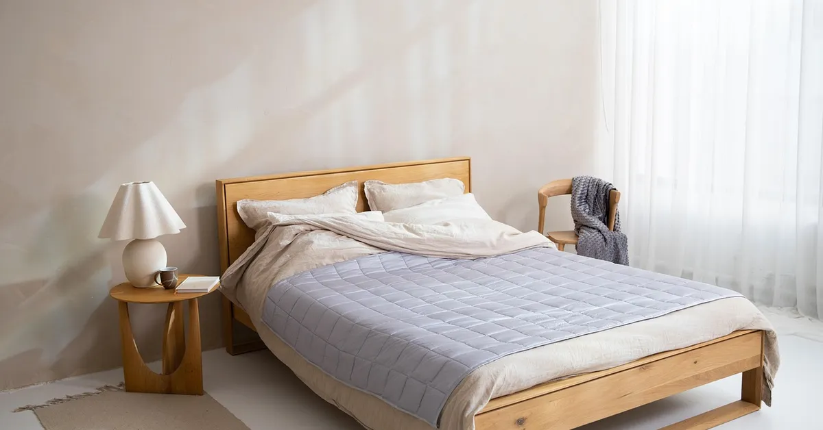 Solid wood cot with a plain wood headboard in a bright bedroom