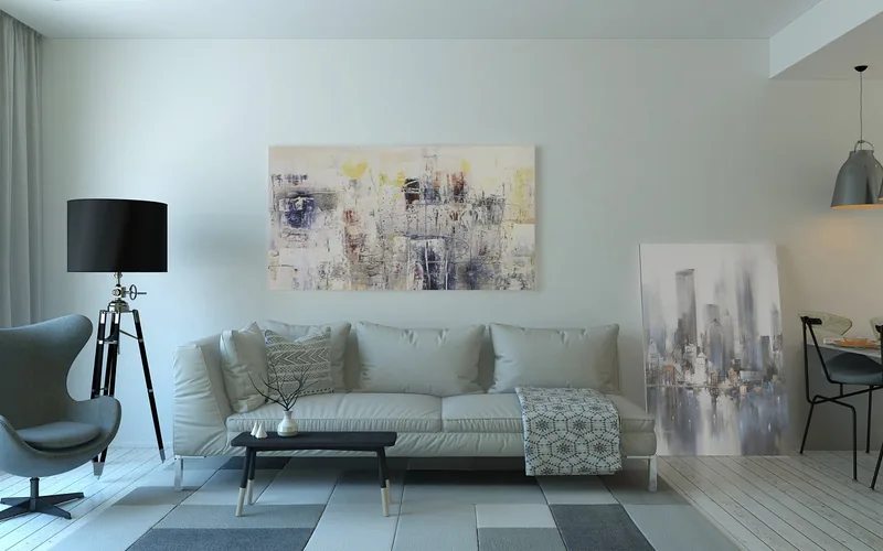 Neutral fabric sofa styled with a floor lamp and wall art in a minimalist living room