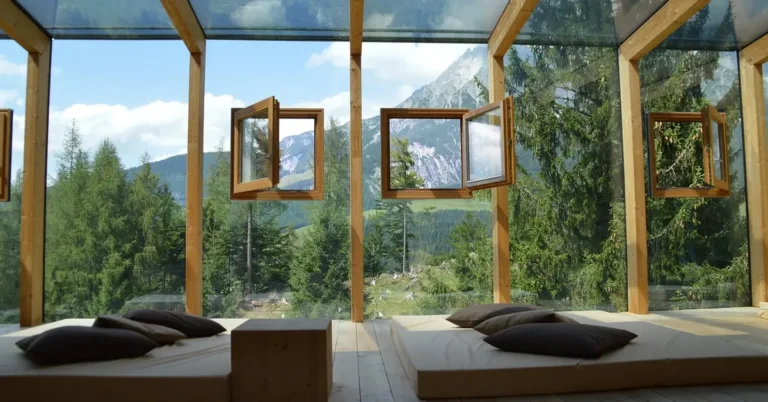 Wood-framed casement windows opening onto a mountain view in a modern luxury home