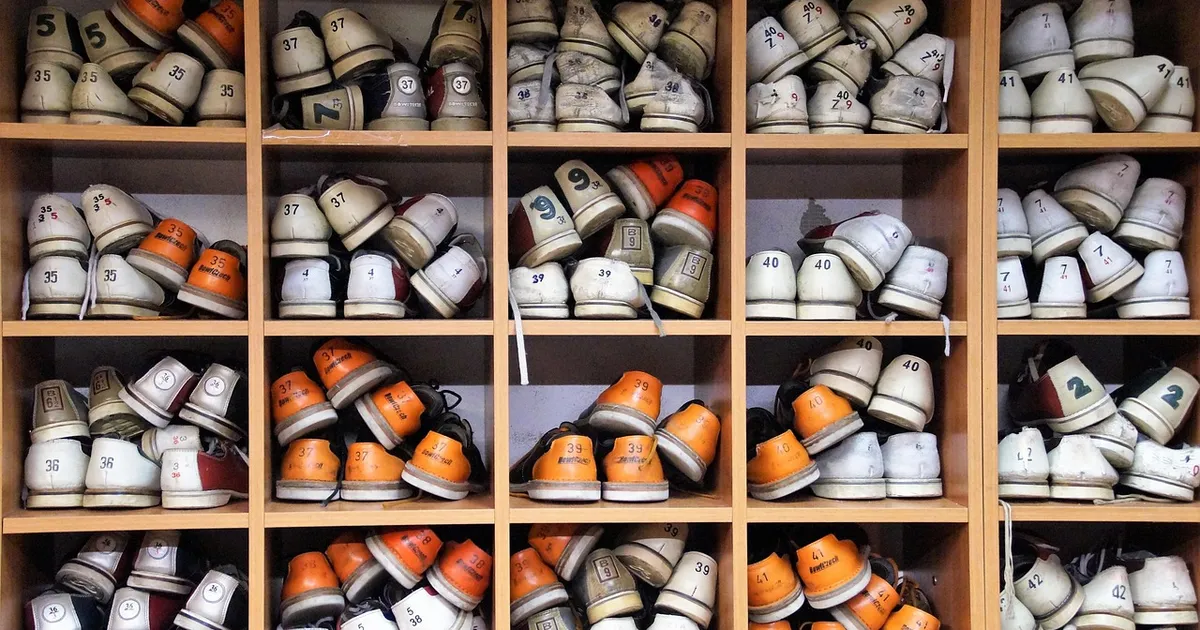 Wooden shelving units holding many pairs of shoes