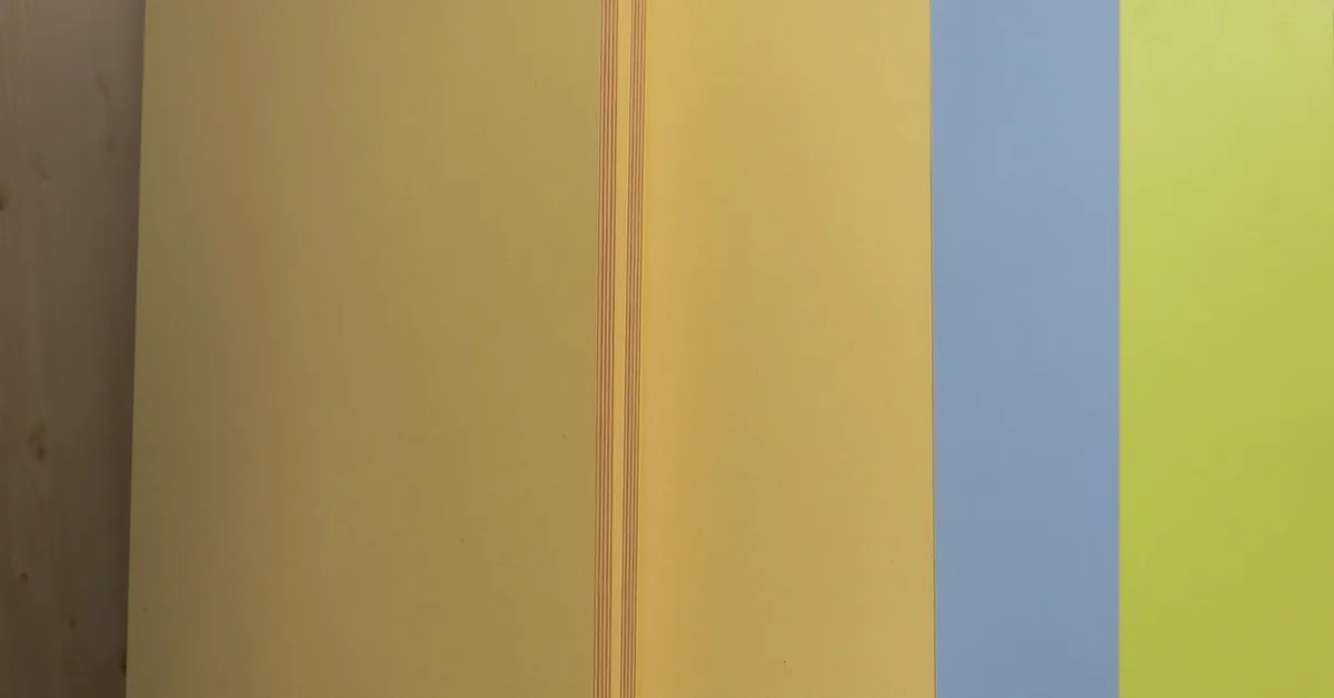 Stack of colored MDF panels displayed at a hardware store, showing the flat smooth cut edge typical of medium-density fi