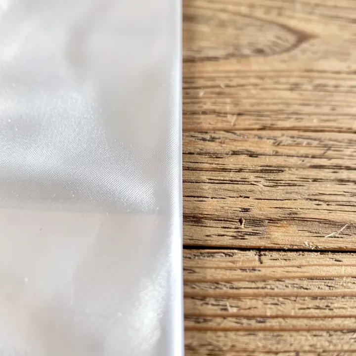 A wood board showing a clear protective finish coating next to raw untreated wood grain