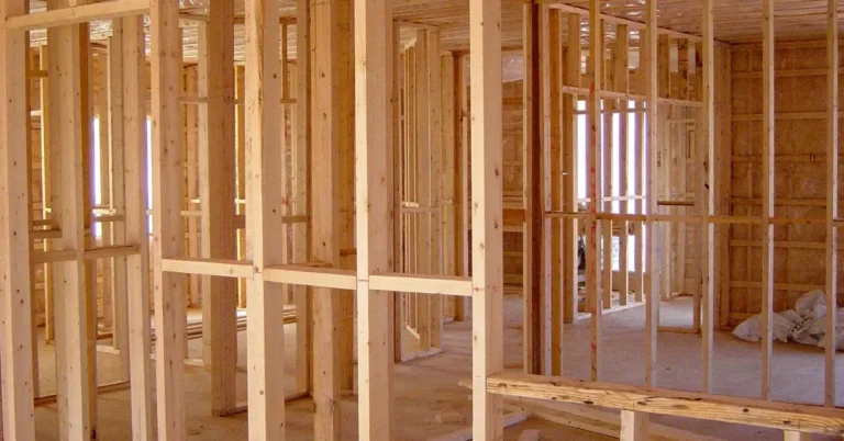 New home under construction with exposed wood floor and wall framing before subfloor installation