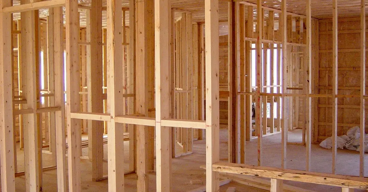 New home under construction with exposed wood floor and wall framing before subfloor installation