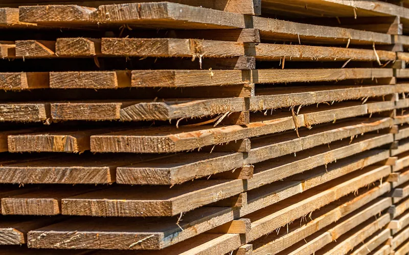 Sawn lumber boards stacked by thickness at a lumber yard Sawn lumber boards stacked by thickness at a lumber yard, mirroring how plywood is graded by nominal size