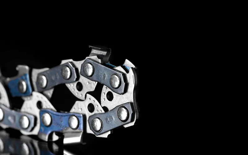 close-up of chainsaw chain drive links and rivets showing pitch spacing close-up of chainsaw chain drive links and rivets showing pitch spacing
