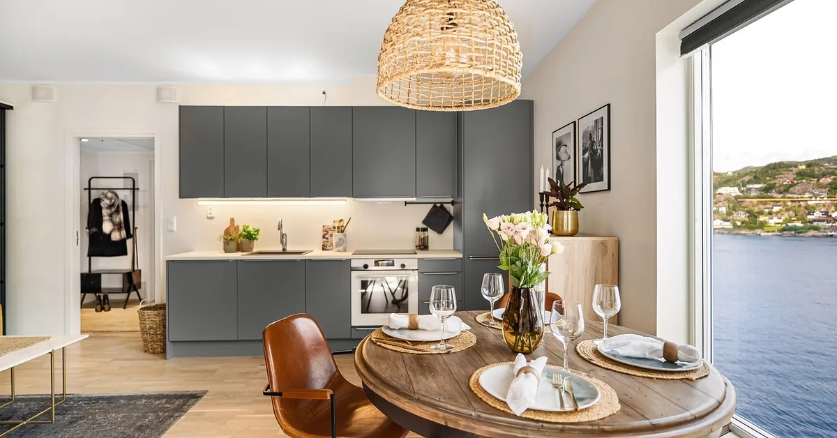 Round wooden dining table paired with leather chairs in a modern kitchen