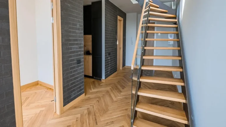 Herringbone oak hardwood floor in a hallway with a wooden staircase