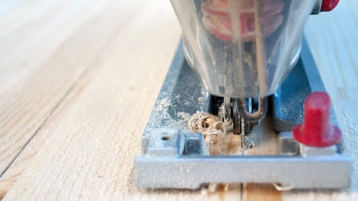 Jigsaw blade seated in the clamp while cutting a pine board