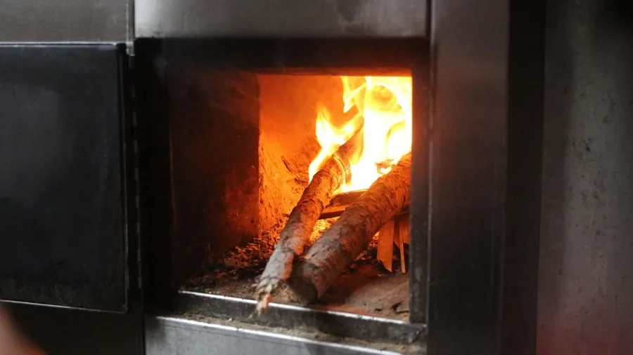 Split logs burning in a closed stove firebox