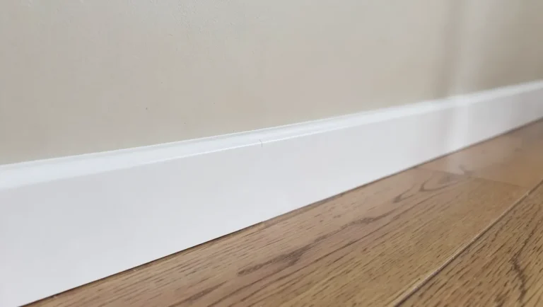 White MDF baseboard trim with a clean caulked seam