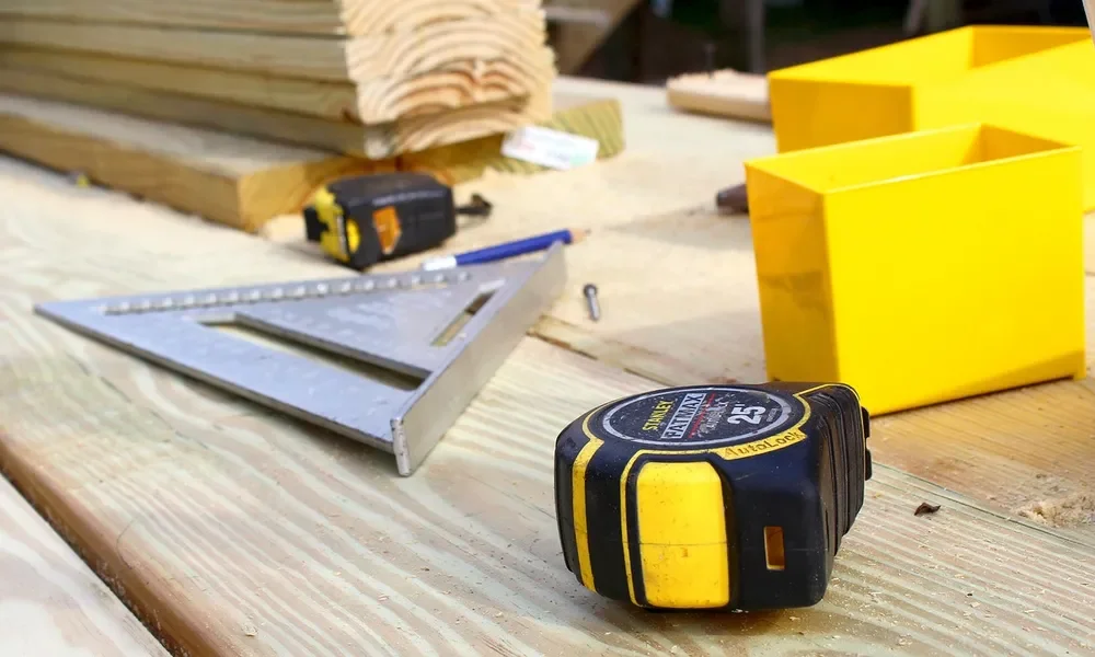 Tape measure, speed square and pencil on lumber for laying out MDF drawer parts