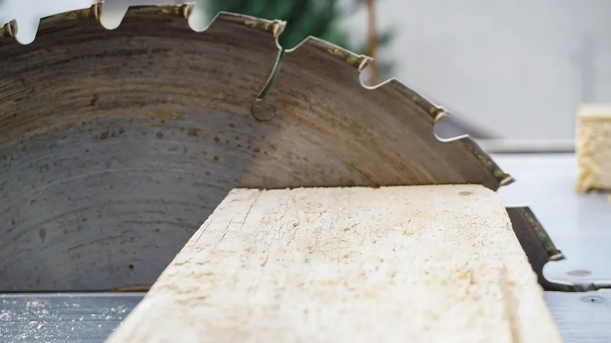 Circular saw blade beside a cut board with sawdust, where MDF dust is released