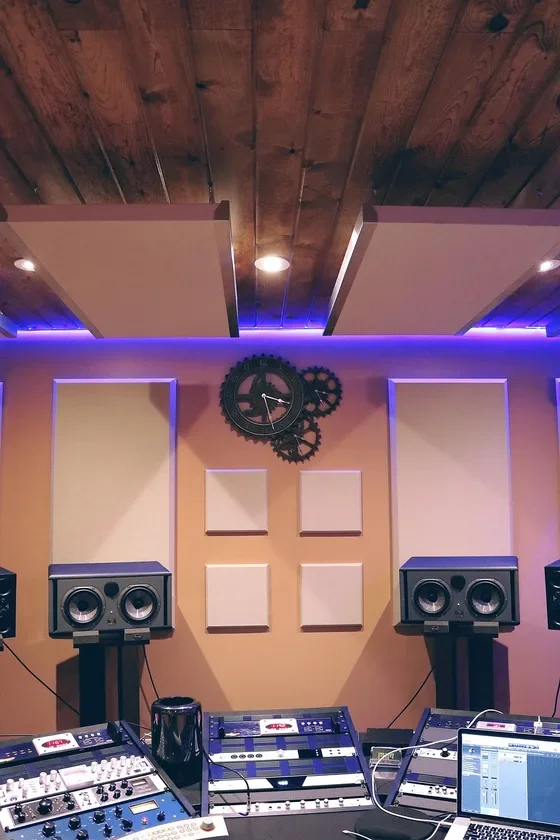 Recording studio wall with fabric-wrapped absorber panels and studio monitors on stands