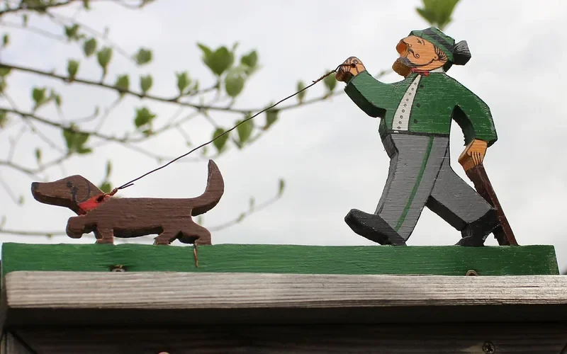 painted wooden cutout of a man walking a dachshund, a typical scroll saw yard project painted wooden cutout of a man walking a dachshund, a typical scroll saw yard project