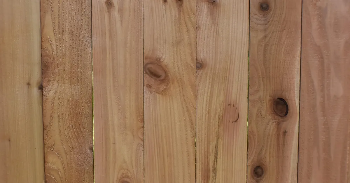 Wood fence boards with knots and reddish-brown grain