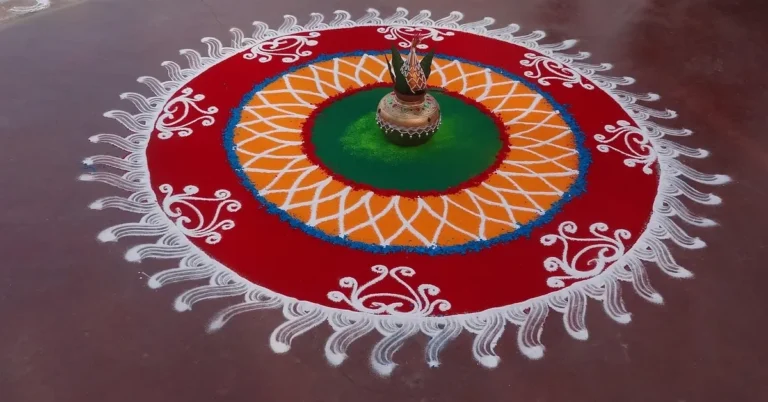 Colorful floor rangoli with a white scalloped border and central lamp