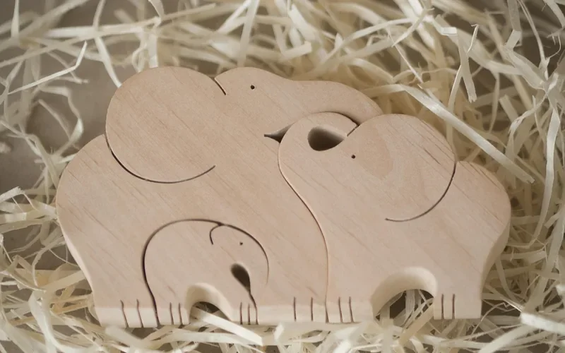 nested wooden elephant puzzle pieces cut from solid wood resting on wood shavings nested wooden elephant puzzle pieces cut from solid wood resting on wood shavings