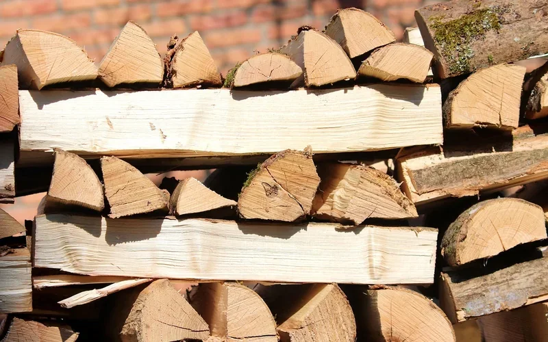 Split firewood stacked in rows against a brick wall to dry Split firewood stacked in rows against a brick wall to dry