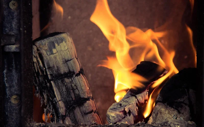Flames and burning logs inside a wood stove firebox Flames and burning logs inside a wood stove firebox