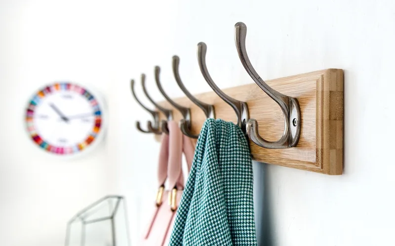 Adhesive hook mounted on a wall holding an item without any drilled holes