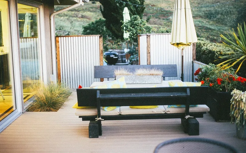 backyard wood deck with patio furniture near a pool