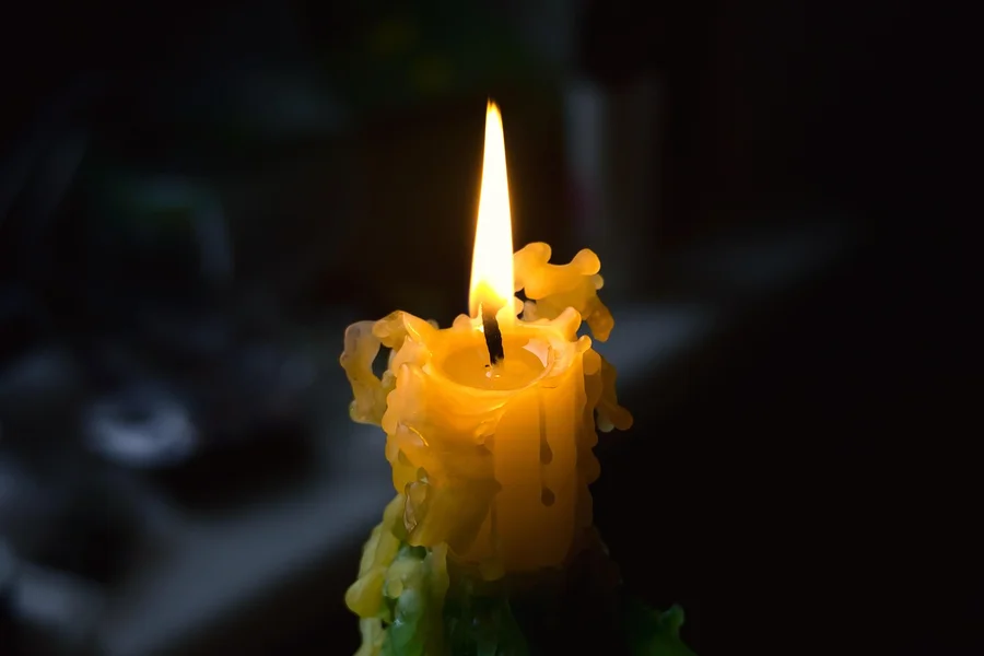 Melted candle wax softened by heat before scraping off a hardwood floor