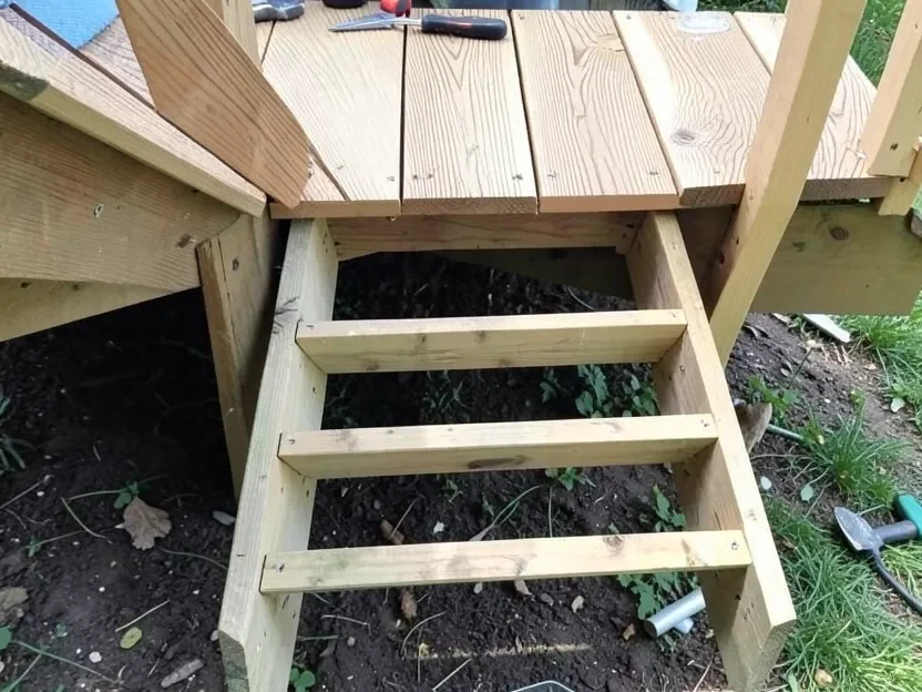 Wooden stair stringers being built as the structural support frame for outdoor deck steps, before composite tread boards are attached
