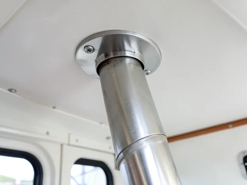 Marine wood stove chimney passing through a boat cabin ceiling with a weatherproof deck fitting