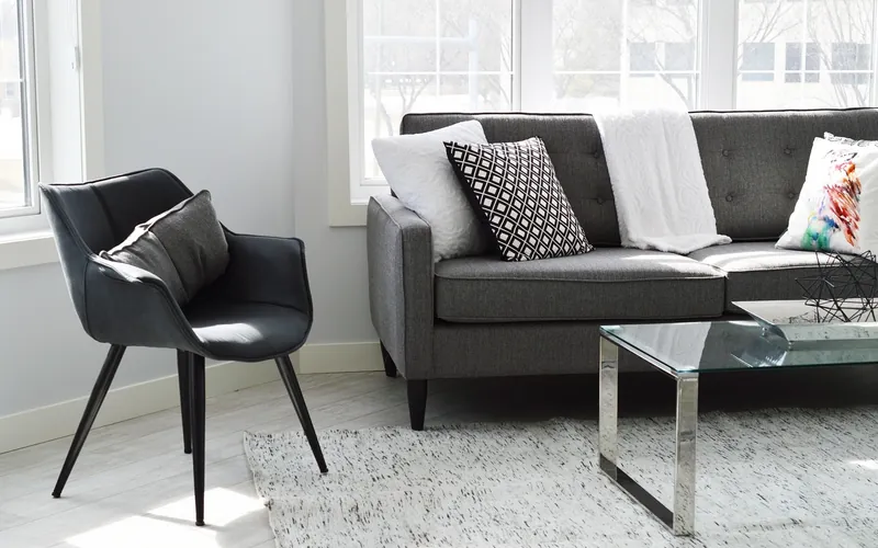 Gray sofa with short dark legs standing on a light wood floor