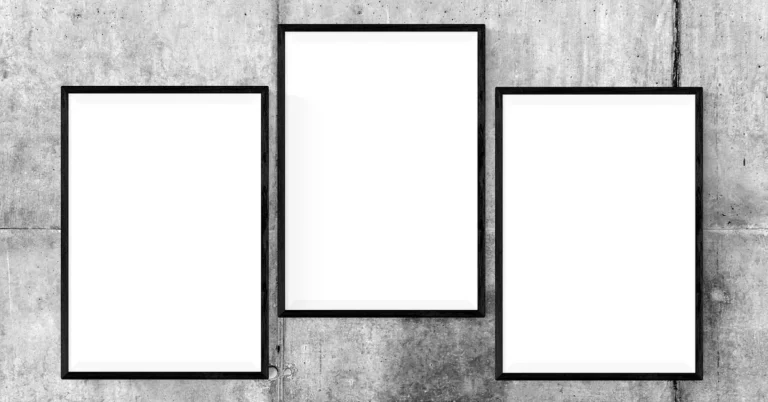 Three black picture frames hung on a gray concrete wall