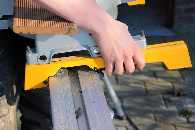 Woodworker locking the miter angle before making a bevel cut on a compound miter saw
