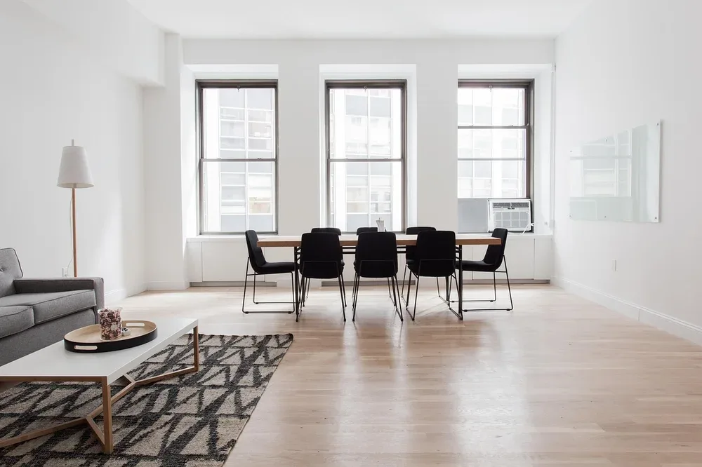 Living room with an area rug on a hardwood floor, a common mixed-flooring layout Living room with an area rug on a hardwood floor, a common mixed-flooring layout